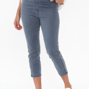 Person wearing light blue jeans and white sneakers on a white background