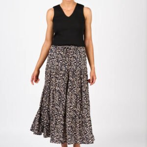 Woman wearing a black sleeveless top and patterned skirt on a white background