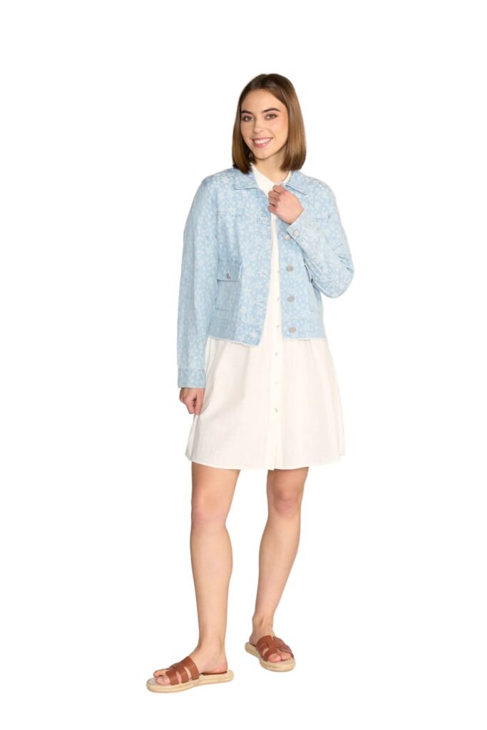 Woman wearing a light blue denim jacket over a white dress on a white background