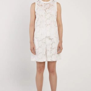 Woman wearing a white floral dress on a plain background